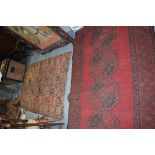 A RED GROUND PERSIAN RUG, together with another similar. Largest 210 cm x 126 cm.