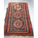 AN EARLY 20TH CENTURY RED GROUND RUG, decorated with motifs. 145 cm x 86 cm.