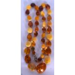 AN LONG AMBER BEAD NECKLACE, formed with varying mixed boulders. Length 70 cm, largest bead 2.8 cm a