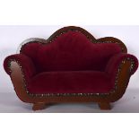 AN APPRENTICE SETTEE, with crimson upholstery and metal studwork. 42 cm wide