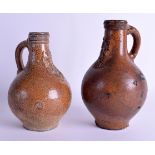 TWO 17TH CENTURY GERMAN BELLARMINE JUGS decorated with mask heads. 20 cm & 19 cm high. (2)