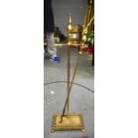 AN EARLY 20TH CENTURY BRASS FIRE STAND, with associated tool. 61 cm high.