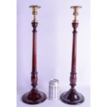 A LARGE PAIR OF EDWARDIAN MAHOGANY CANDLESTICKS. 53 cm high.