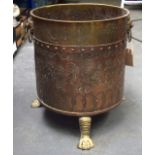 AN EARLY 20TH CENTURY COPPER AND BRASS LOG BIN, formed with lion mask head handles, paw feet and eng