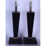 A PAIR OF STYLISH BLACK LAMP, of tapering form on pedestal base. 57 cm high.