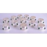 A SET OF TWELVE SILVER PLATED NAPKIN RINGS set with green stones. (12)