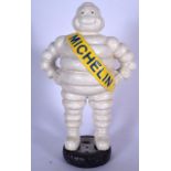 A LARGE CAST IRON STATUE OR FIGURE OF THE MICHELIN MAN, modelled standing upon a tyre. 41 cm high.