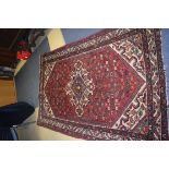 A LARGE RED GROUND PERSIAN RUG, decorated with foliage. 246 cm x 142 cm.