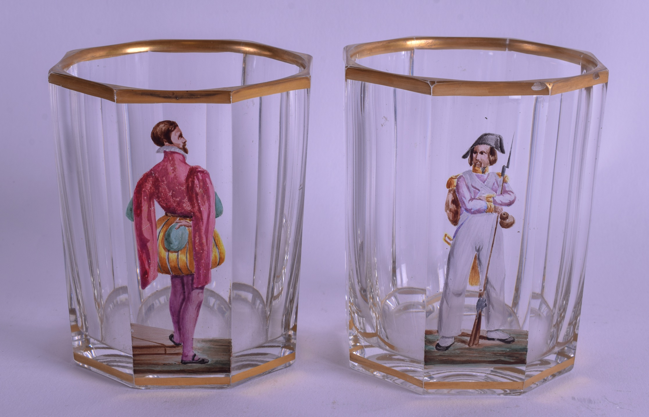 A PAIR OF EARLY 19TH CENTURY AUSTRO GERMAN ENAMELLED GLASSES painted with figures under a gilt rim.