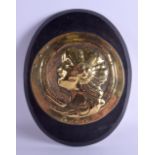 AN ARTS AND CRAFTS BRASS WALL HANGING ROUNDEL depicting a female upon an ebonised shield. Brass 22 c