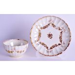 AN 18TH CENTURY JAMES GILES GILDED WORCESTER TEABOWL AND SAUCER decorated with flowers under a sawto