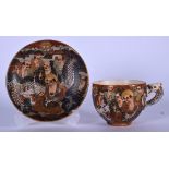 A JAPANESE SATSUMA POTTERY TEA CUP AND SAUCER, decorated with immortals beside a dragon. (2)