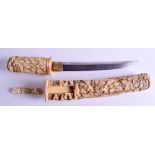 A 19TH CENTURY JAPANESE MEIJI PERIOD CARVED IVORY TANTO DAGGER decorated with figures within landsca