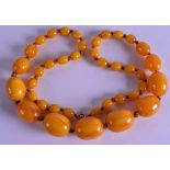 A 1920S CARVED AMBER NECKLACE. 87 grams. 64 cm long.