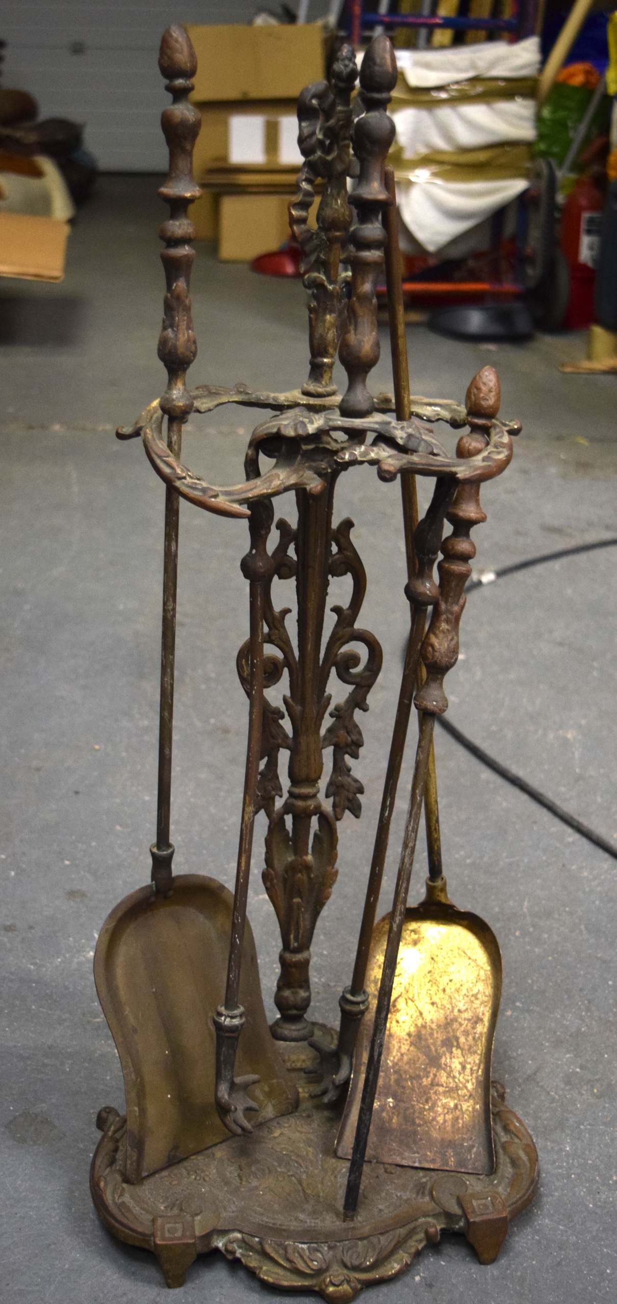 A SET OF VICTORIAN FIRE TOOLS, together with associated stand, decorated in relief with foliage. 68