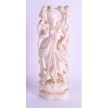 A 19TH CENTURY ANGLO INDIAN CARVED IVORY FIGURE OF A DEITY modelled standing upon a lotus flower. 19