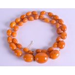 A GOOD EARLY 20TH CENTURY CHINESE TIBETAN CARVED AMBER NECKLACE of graduated form. 69 grams. 75 cm l