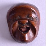 A 19TH CENTURY JAPANESE MEIJI PERIOD CARVED BOXWOOD NETSUKE in the form of a mask. 3.5 cm x 2.75 cm.