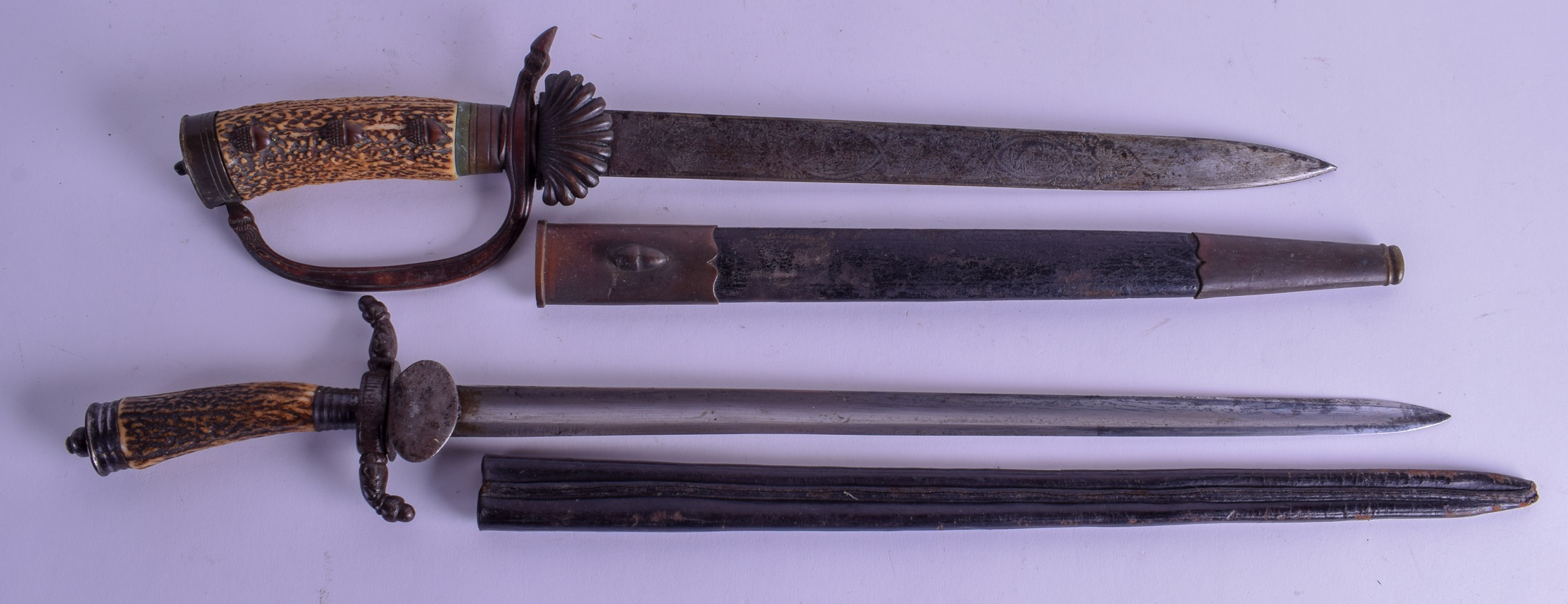 TWO SMALLER ANTIQUE GERMAN ANTLER HORN HANDLED SWORDS one with shell cap to scabbard. 50 cm & 53 cm