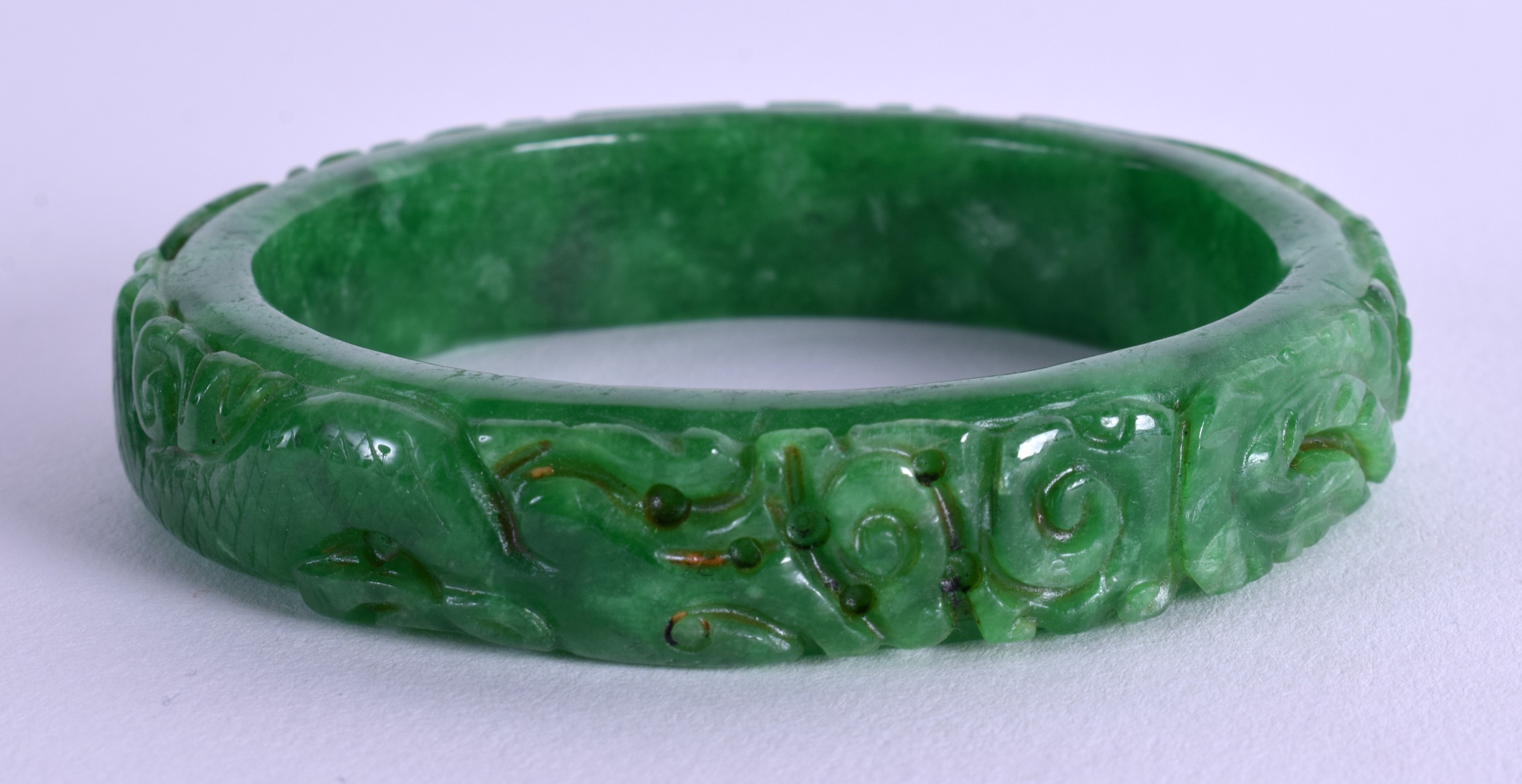 A CHINESE CARVED JADEITE BANGLE. 7.25 cm wide.