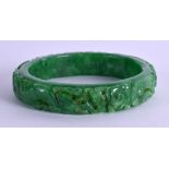 A CHINESE CARVED JADEITE BANGLE. 7.25 cm wide.