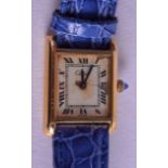 AN 18CT GOLD PLATED CARTIER WRISTWATCH with blue leather strap. 1.75 cm x 2.5 cm. (2)