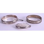 A SILVER LOCKET with two silver bangles. 69 grams. (3)