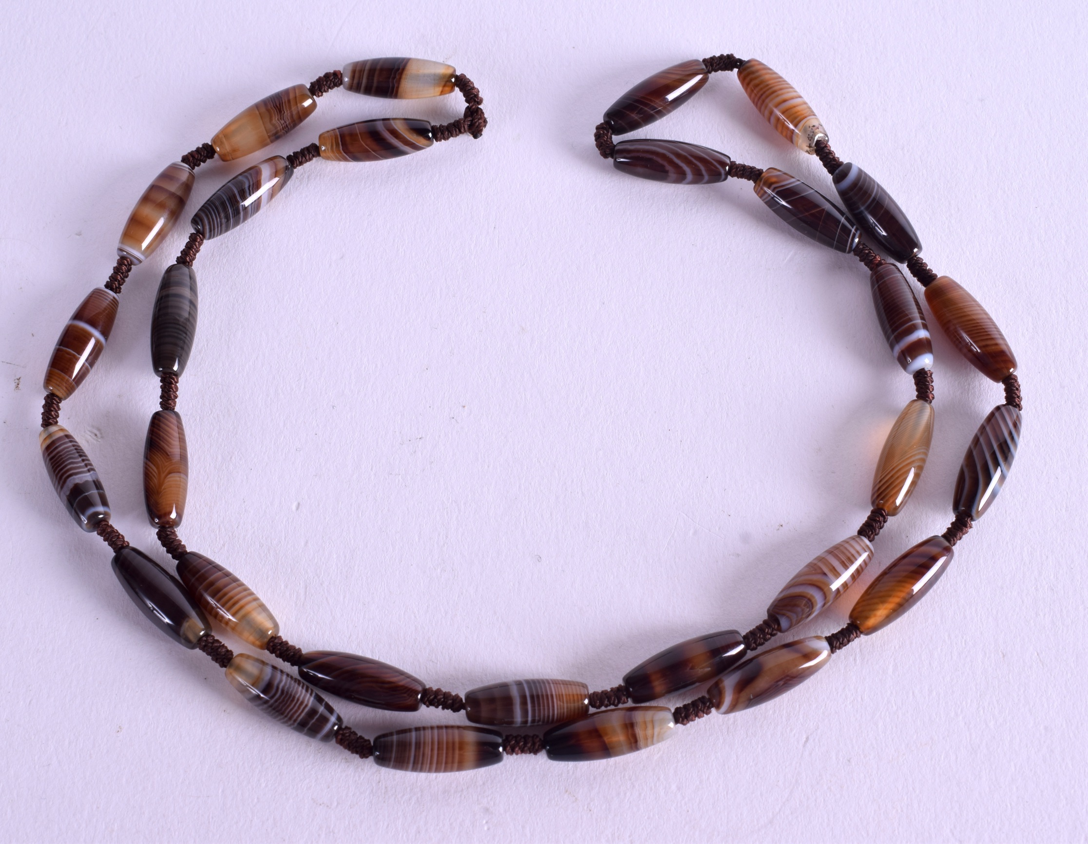 A BANDED AGATE NECKLACE. 56 cm long.