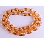 AN AMBER TYPE NECKLACE. 70 cm long.