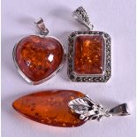 THREE SILVER AND AMBER PENDANTS. (3)