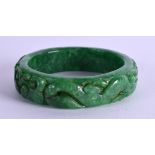 A CHINESE CARVED JADE BANGLE. 7 cm wide.