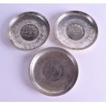 THREE CHINESE WHITE METAL COIN DISHES. 9 cm wide. (3)