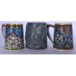 THREE ISLAMIC MIDDLE EASTERN IZNIK TYPE TANKARDS, decorated with foliage in varying form. Largest 11