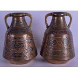A PAIR OF 19TH CENTURY MIDDLE EASTERN SILVER INLAID BRASS VASES decorated with scrolls and foliage.