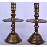 A PAIR OF EARY 20TH CENTURY BRASS CANDLESTICKS, formed with large drip tray and seven knopped stem.