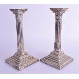 A PAIR OF ANTIQUE SILVER PLATED CORINTHIAN COLUMN CANDLESTICKS. 22 cm high.