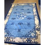 A LARGE EARLY 20TH CENTURY CHINESE BLUE GROUND RUG, decorated with bats and shou characters. 240 cm