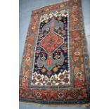 AN ANTIQUE NORTHWEST PERSIAN TRIBAL RUG, decorated with symbols and foliage. 195 cm x 115 cm.