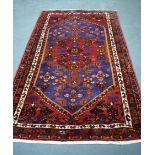 A 20TH CENTURY PERSIAN RED GROUND HAMADAN RUG, decorated with symbols and motifs. 220 cm x 134 cm.