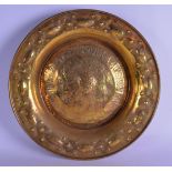A 19TH CENTURY BRASS FIRESIDE CIRCULAR EMBOSSED CHARGER bearing spurious date 1503. 46 cm diameter.