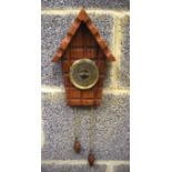 A CARVED WOODEN WALL BAROMETER, forming the roof of a house, lattice type carved body. 26 cm high.