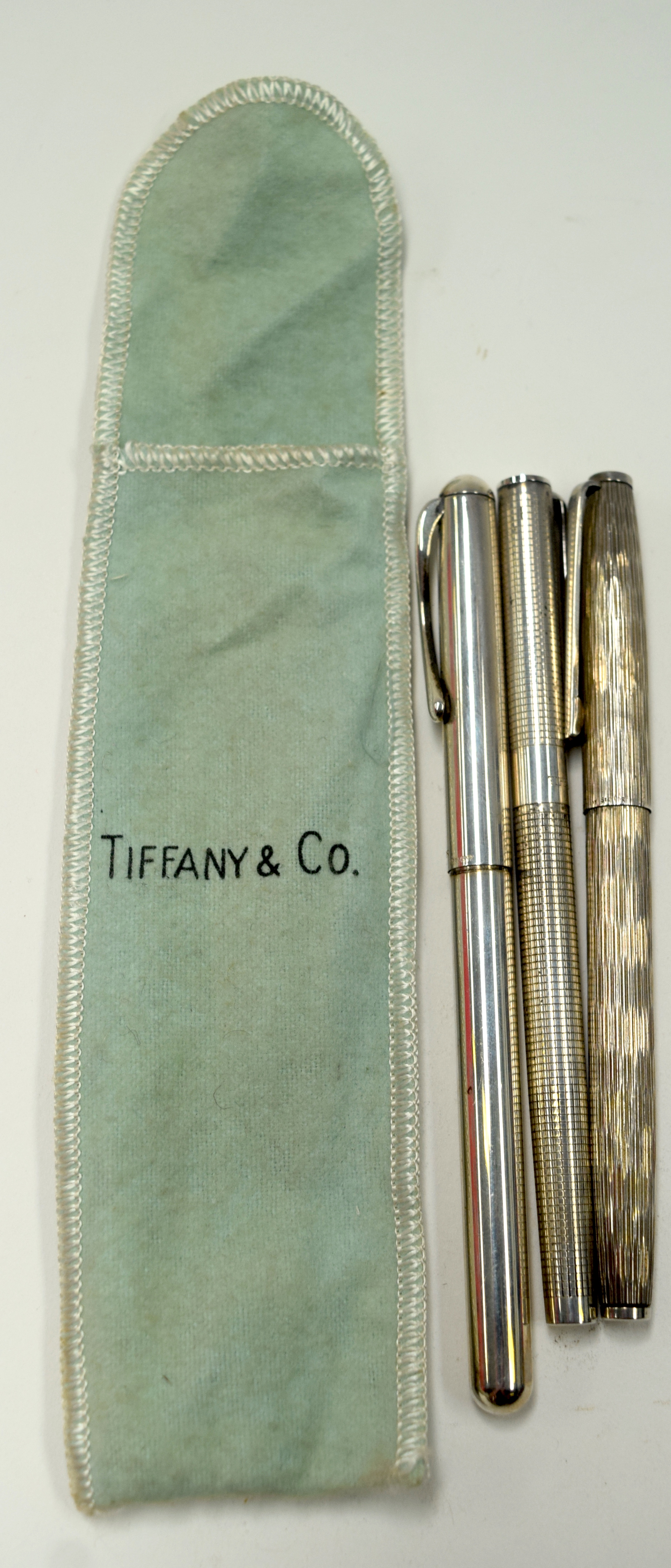 A SOLID SILVER TIFFANY & CO SOLID SILVER PEN, together with two other pens. (3)