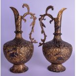 A PAIR OF 19TH CENTURY INDIAN BRASS ALLOY JUGS decorated with figures hunting elephants upon a roco