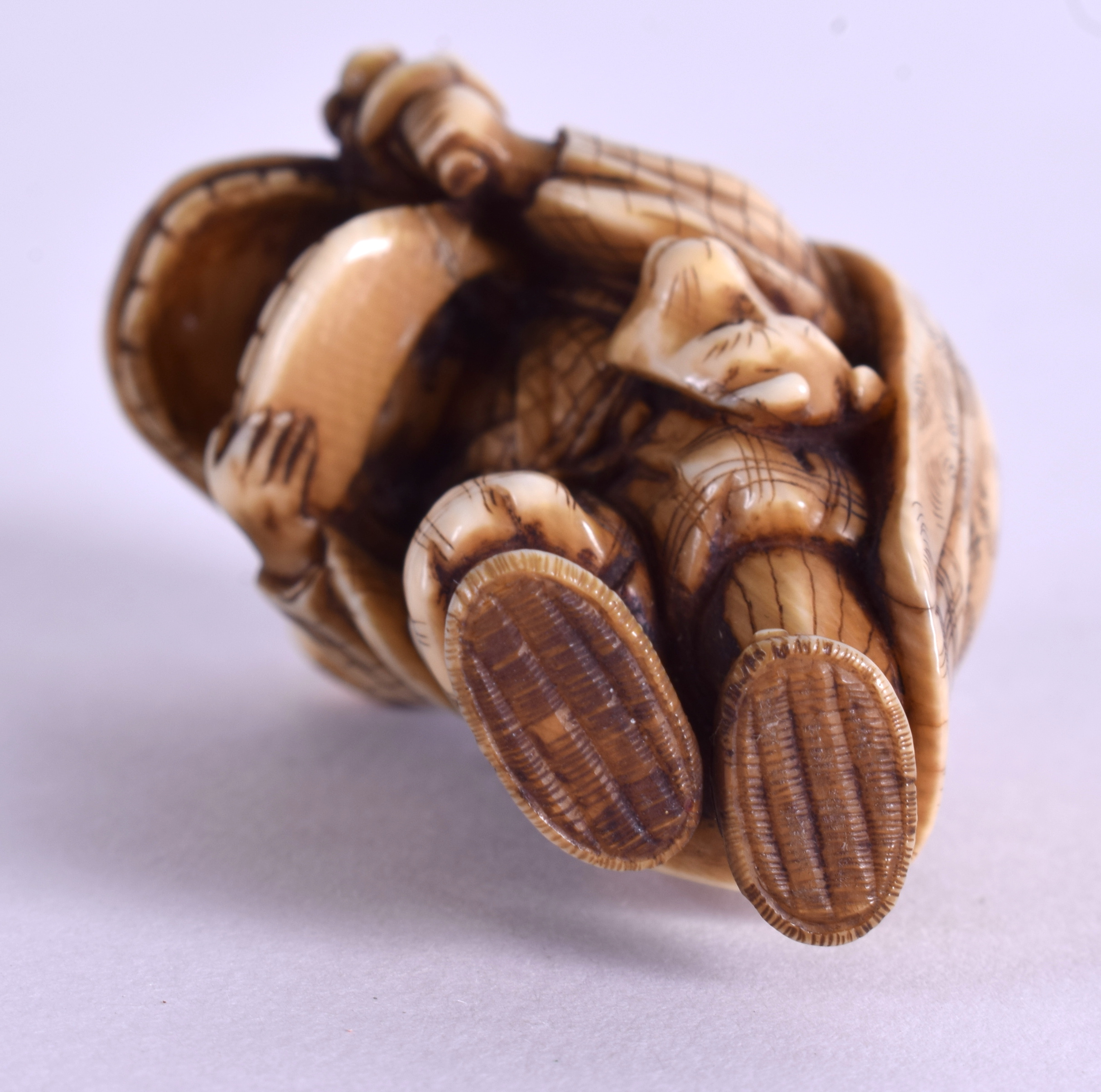 A 19TH CENTURY JAPANESE MEIJI PERIOD CARVED IVORY NETSUKE modelled as a male wearing a mask. 4.75 c - Image 4 of 4