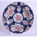 AN 18TH CENTURY WORCESTER PLATE painted with bold flowers and cartouches. 18.5 cm wide. Provenance: