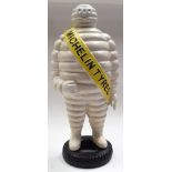 A HUGE CAST IRON FIGURE OF THE MICHELIN MAN, modelled standing upon a tyre. 61 cm high.