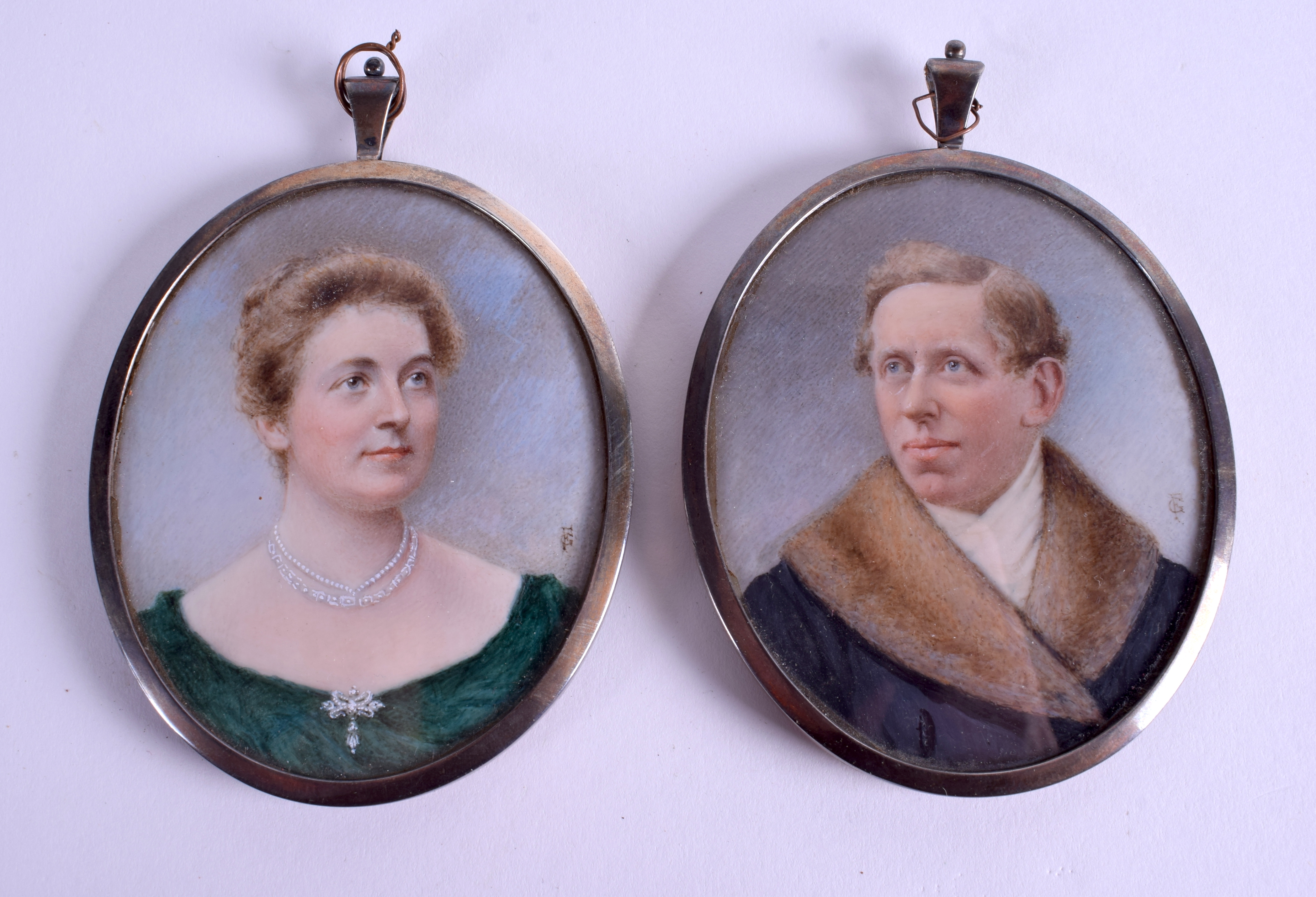 A PAIR OF LATE 19TH CENTURY PAINTED IVORY PORTRAIT MINIATURES within silver frames. 6.5 cm x 7.5 cm