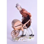 A 19TH CENTURY GERMAN ANSPACH NASSAU FIGURE OF A BOY modelled pushing a wheel barrow. 13.5 cm high.