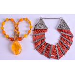 AN EARLY 20TH CENTURY TIBETAN CORAL NECKLACE together with an amber type necklace. (2)