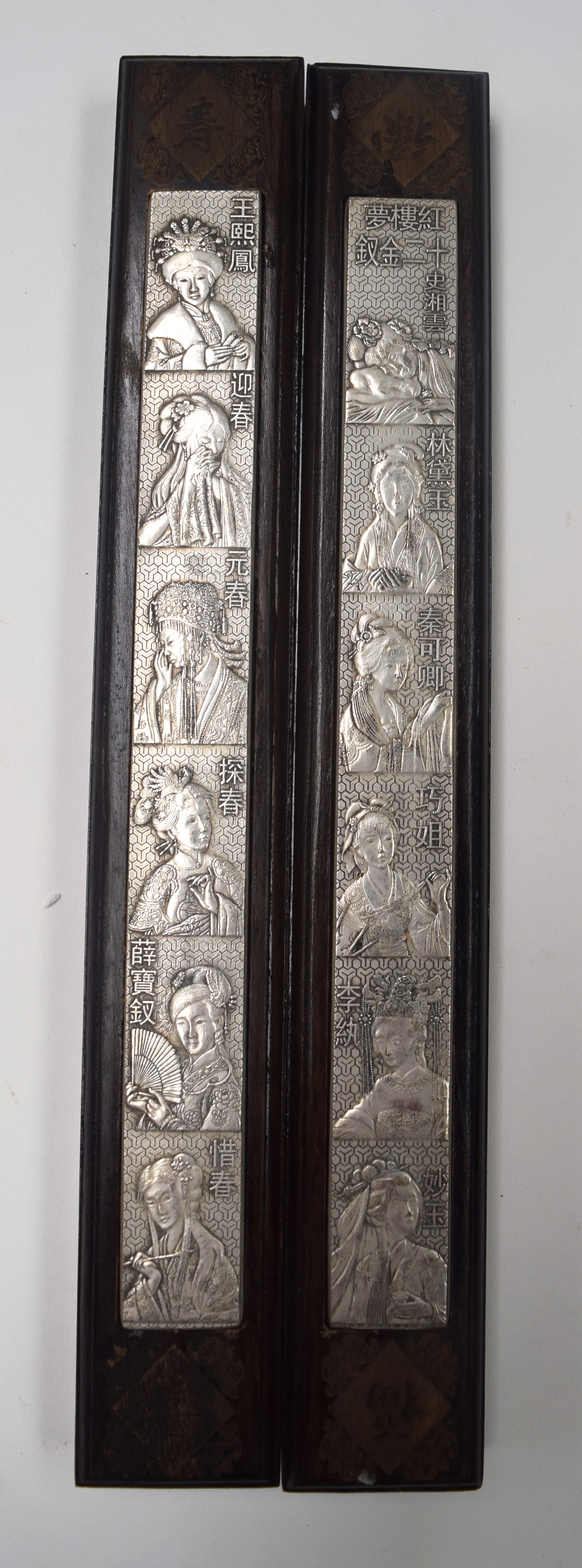 A PAIR OF CHINESE WHITE METAL INSET WOODEN PANELS, decorated with female portraits. 29.5 cm long.